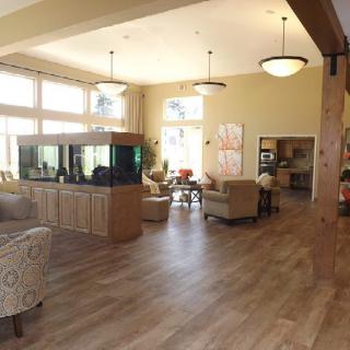 A spacious and well-lit living area with comfortable seating, a large aquarium, and expansive windows.
