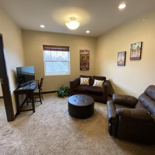 A cozy living room with a sofa, armchair, TV, and coffee table.