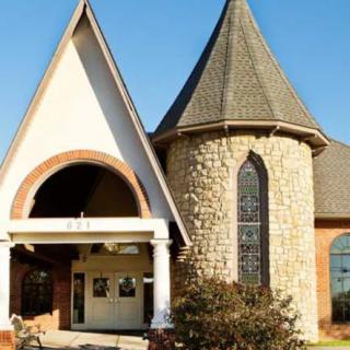 A church building with a stone tower and arched entrance.