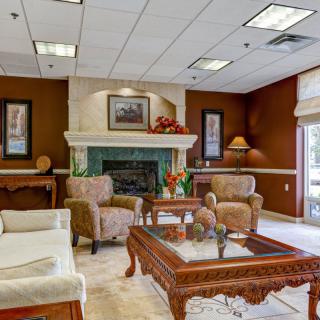 A cozy living room with comfortable seating and a fireplace, featuring traditional decor.