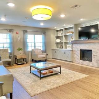 A modern living room with a cozy atmosphere, featuring a fireplace, built-in shelves, and stylish furniture.
