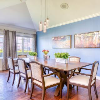 A bright dining room with a large table, chairs, and stylish decor.