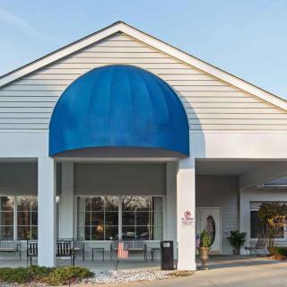 A building entrance with a blue awning and large windows.