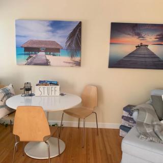 Cozy living room with a dining area, featuring beach-themed wall art and warm decor.