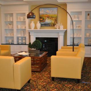 A cozy living room featuring yellow armchairs, a fireplace, and elegant decor elements.