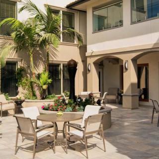 A spacious patio with outdoor furniture and lush greenery.