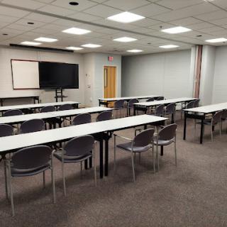 A spacious conference room set up with tables and chairs, ready for a meeting or presentation.