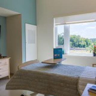 A bright and cozy bedroom with a large window allowing natural light to flood in.