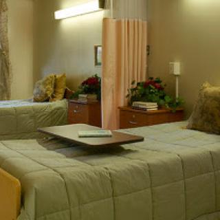 A cozy hospital room featuring two patient beds, designed for comfort and privacy.