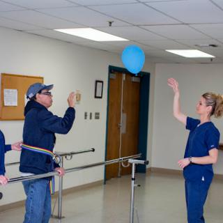 Patients engaging in a therapeutic exercise session involving a balloon.