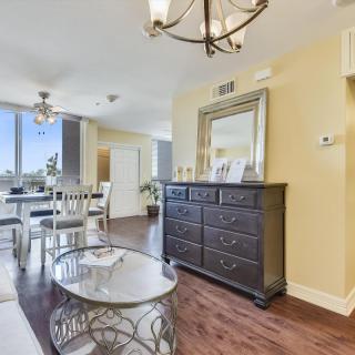 A bright and spacious living and dining area featuring elegant furniture and ample natural light.