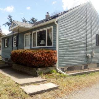 A charming single-story house with blue siding and a well-maintained front yard.