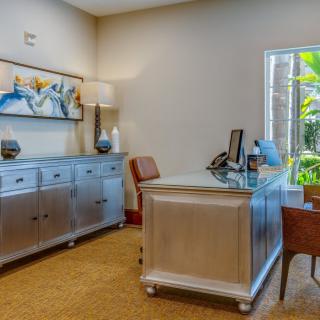 A neatly arranged office space with a desk, chairs, and decorative elements.