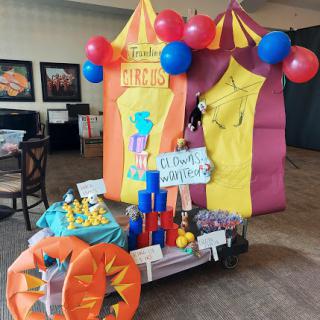 A vibrant circus-themed play area decorated with balloons and colorful tents, perfect for children's entertainment.