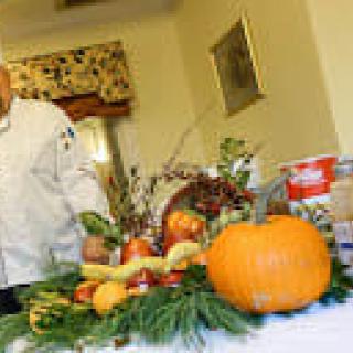 A chef preparing a display of fruits and vegetables in the kitchen.