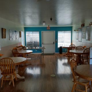 An empty cafe interior with wooden tables and chairs.