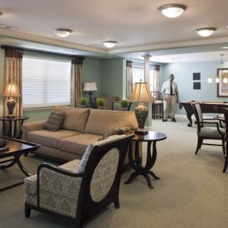 A well-furnished living room with a sofa, chairs, coffee table, and elegant lamps.