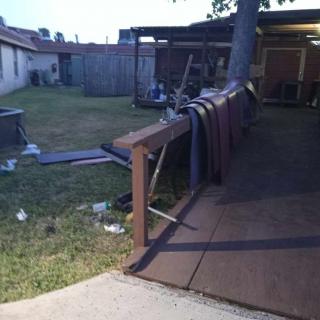 A backyard view featuring a wooden deck and fence during the evening.