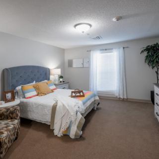 A cozy bedroom with a neatly made bed, soft lighting, and tasteful decor.