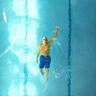 A swimmer diving through the clear blue water of a pool.