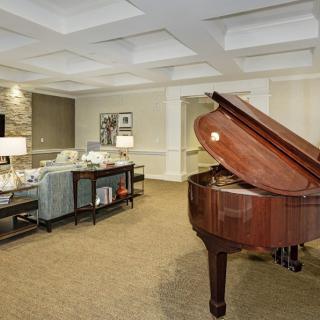A luxurious living room featuring a grand piano and elegant furnishings.