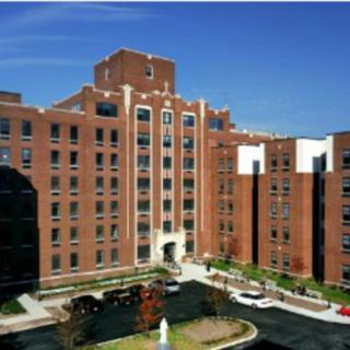 A large brick hospital building with multiple floors and a central entrance.