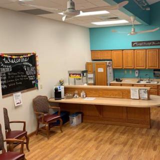 A cozy reception area with a small kitchenette and seating.