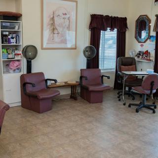 A cozy salon interior featuring hair dryers and a nail station.