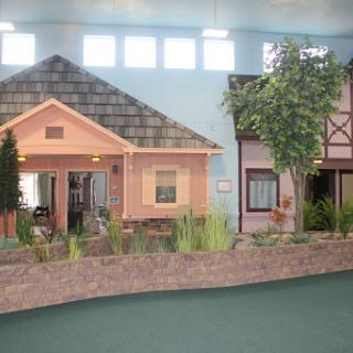 A display of model homes showcasing different architectural styles in an indoor setting.