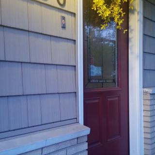 A home entrance featuring a red door and siding.