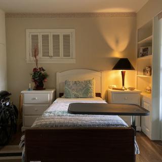 A cozy bedroom with a lamp and nightstand beside the bed.