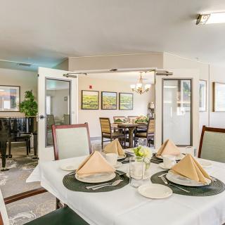 A well-arranged dining area with elegant table settings and bright decor.