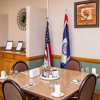 A conference room with a dining setup featuring flags and wall art.