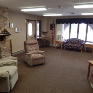 A cozy living room with comfortable seating, a brick fireplace, and natural lighting.