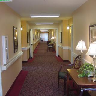 A well-lit indoor hallway with furniture and decor along the sides.