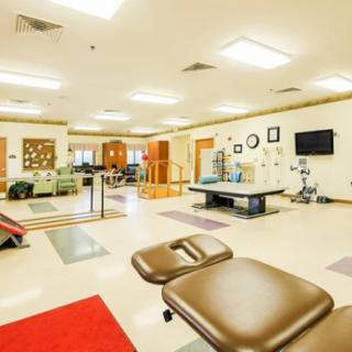 A spacious physical therapy room equipped with various exercise and treatment areas.