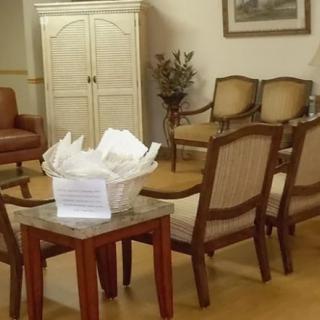 A waiting room featuring several chairs arranged around a wooden table.