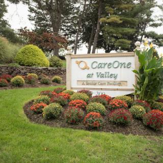 A beautifully landscaped garden with a sign for CareOne at Valley.