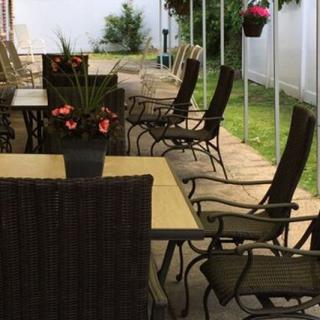 Outdoor patio area with tables, chairs, and decorative plants.