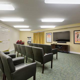 A spacious home theater room with arranged seating and a large television screen.