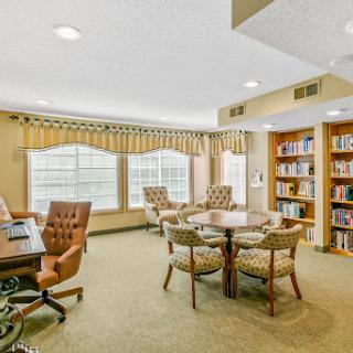 A cozy library space featuring comfortable seating and a collection of books.