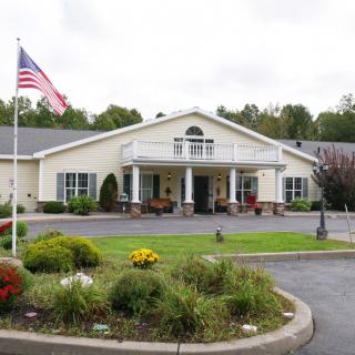 A building with a landscaped entrance and an American flag.