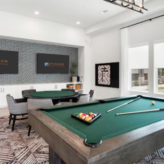 A stylish game room featuring a green pool table and contemporary furnishings, perfect for leisure and entertainment.