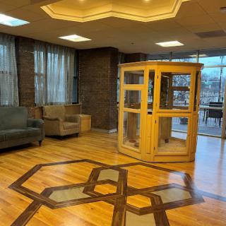 A well-designed lobby featuring a wooden structure, comfortable seating, and elegant flooring.