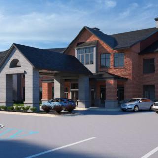 A modern residential building with a parking lot and cars in front.