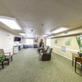 A spacious and well-lit living room with comfortable seating and a television.