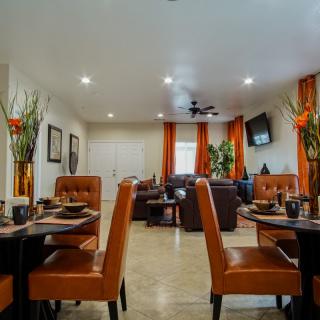 A modern dining room with neatly arranged tables and chairs, featuring stylish decor and lighting.