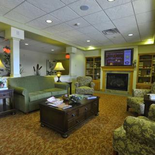 A cozy living room with comfortable seating, a fireplace, and bookshelves.
