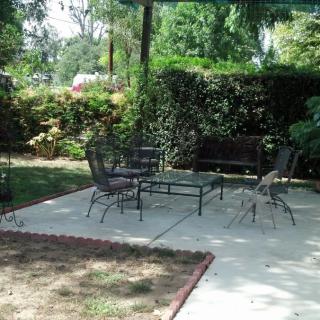 A peaceful garden patio with outdoor furniture and lush greenery.