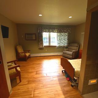 A cozy and well-lit room featuring wooden flooring and comfortable furniture.